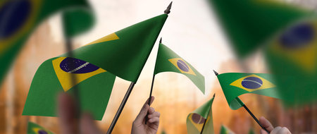 Brazil flags in their hands on a blurred urban background