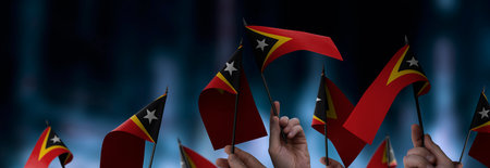 East Timor flags in their hands on a blurred urban backgroundの写真素材