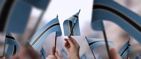 Botswana flags in their hands on a blurred urban backgroundの写真素材