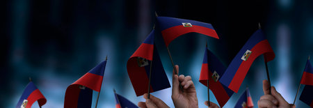 Haiti flags in their hands on a blurred urban background