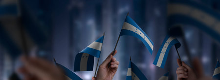 Honduras flags in their hands on a blurred urban background. The photo illustration was created without the use of artificial intelligence, only using Photoshop.の写真素材