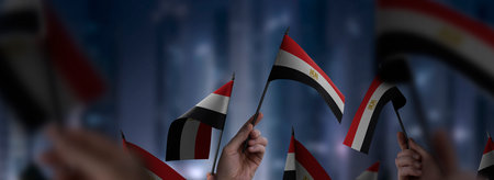 Egypt flags in their hands on a blurred urban background. The photo illustration was created without the use of artificial intelligence, only using Photoshop.の写真素材