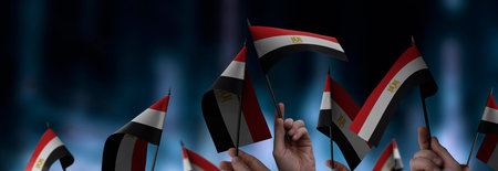 Egypt flags in their hands on a blurred urban backgroundの写真素材