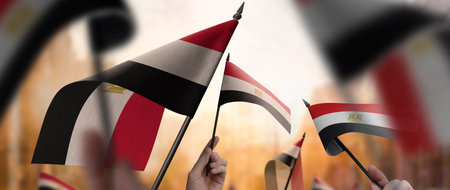 Egypt flags in their hands on a blurred urban backgroundの写真素材