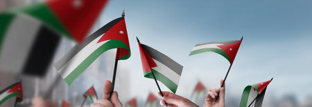 Jordan flags in their hands on a blurred urban backgroundの写真素材