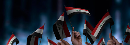 Iraq flags in their hands on a blurred urban backgroundの写真素材