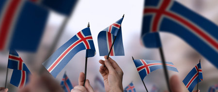 Iceland flags in their hands on a blurred urban backgroundの写真素材
