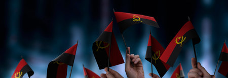 Angola flags in their hands on a blurred urban background