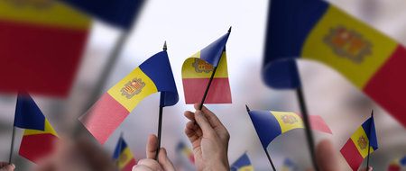 Andorra flags in their hands on a blurred urban backgroundの写真素材