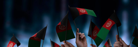 Afghanistan flags in their hands on a blurred urban backgroundの写真素材