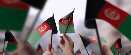 Afghanistan flags in their hands on a blurred urban backgroundの写真素材