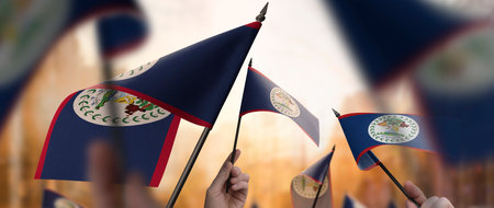 Belize flags in their hands on a blurred urban backgroundの写真素材