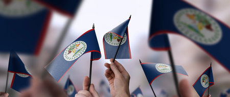 Belize flags in their hands on a blurred urban backgroundの写真素材