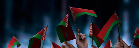 Belarus flags in their hands on a blurred urban backgroundの写真素材