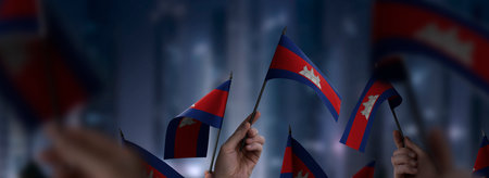 Cambodia flags in their hands on a blurred urban backgroundの写真素材