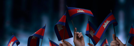 Cambodia flags in their hands on a blurred urban backgroundの写真素材