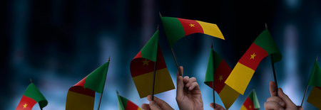 Cameroon flags in their hands on a blurred urban backgroundの写真素材