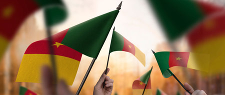 Cameroon flags in their hands on a blurred urban backgroundの写真素材