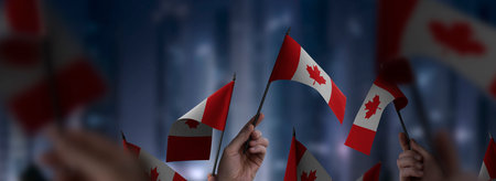 Canada flags in their hands on a blurred urban backgroundの写真素材