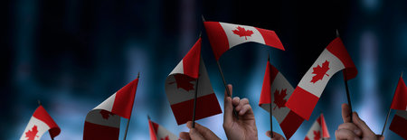 Canada flags in their hands on a blurred urban backgroundの写真素材