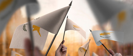 Cyprus flags in their hands on a blurred urban backgroundの写真素材