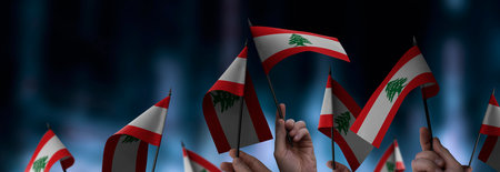 Lebanon flags in their hands on a blurred urban backgroundの写真素材