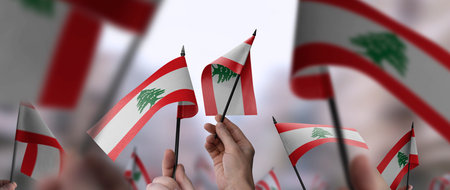Lebanon flags in their hands on a blurred urban backgroundの写真素材