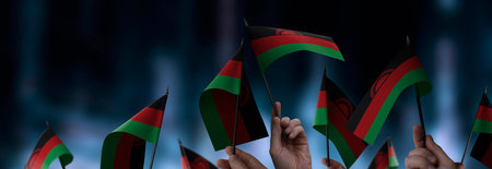 Malawi flags in their hands on a blurred urban background