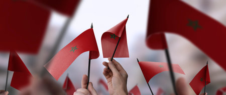 Morocco flags in their hands on a blurred urban background