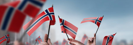 Norway flags in their hands on a blurred urban background