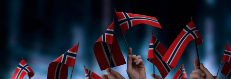Norway flags in their hands on a blurred urban background