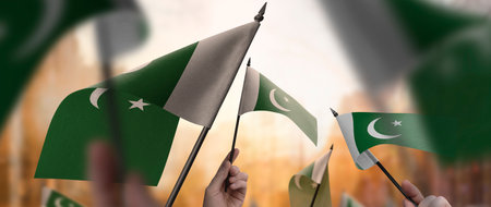 Pakistan flags in their hands on a blurred urban background