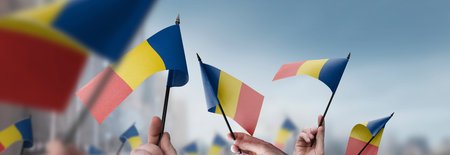 Romania flags in their hands on a blurred urban background
