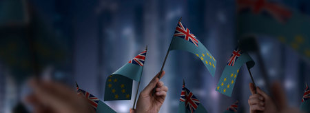 Tuvalu flags in their hands on a blurred urban background