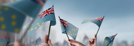 Tuvalu flags in their hands on a blurred urban background