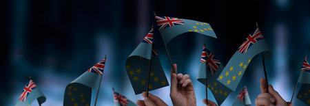 Tuvalu flags in their hands on a blurred urban background