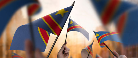 Democratic Republic of the Congo flags in their hands on a blurred urban background