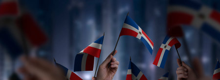 Dominicana flags in their hands on a blurred urban backgroundの写真素材