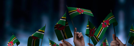 Dominica flags in their hands on a blurred urban backgroundの写真素材