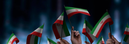 Iran flags in their hands on a blurred urban backgroundの写真素材