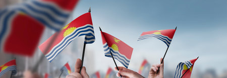 Kiribati flags in their hands on a blurred urban backgroundの写真素材