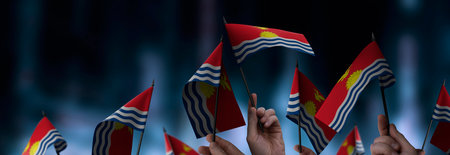 Kiribati flags in their hands on a blurred urban background