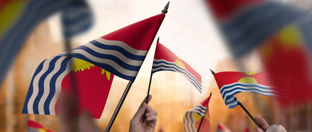 Kiribati flags in their hands on a blurred urban backgroundの写真素材