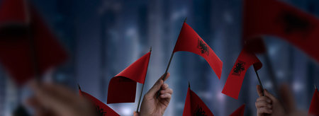 Albania flags in their hands on a blurred urban backgroundの写真素材