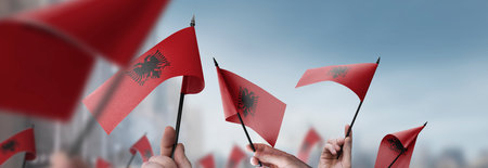 Albania flags in their hands on a blurred urban backgroundの写真素材