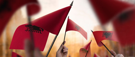 Albania flags in their hands on a blurred urban backgroundの写真素材