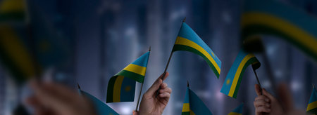 Rwanda flags in their hands on a blurred urban background