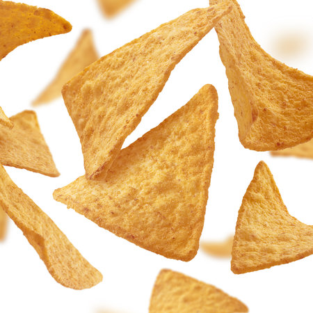 Corn chips of triangular shape levitate on a white backgroundの写真素材
