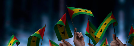 Sao Tome and Principe flags in their hands on a blurred urban backgroundの写真素材