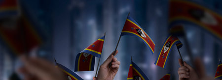 Swaziland flags in their hands on a blurred urban backgroundの写真素材